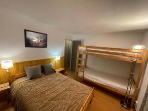 a bedroom with a bed and a bunk bed at Appart 4 pièces, 10 pers, au pied des pistes, Les Menuires, animaux admis, wifi - FR-1-574-3 in Les Menuires