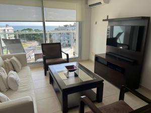 sala de estar con sofá, TV y mesa en Exclusivo depto "Sea&Forest" frente mar P7 Mansa! parada 7 mansa - Punta del este, en Punta del Este