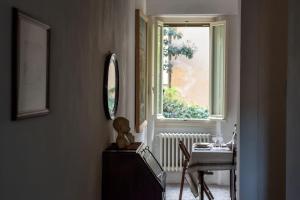 una bambola seduta su un comò in una stanza con finestra di Cozy apartment with private garden - CITY CENTER - a Firenze