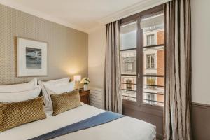 a bedroom with a bed and a window at H&ocirc;tel d'Orsay - Esprit de France in Paris