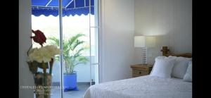 1 dormitorio con 1 cama y un jarrón de flores en Cristales del Mediterraneo, en Girardot