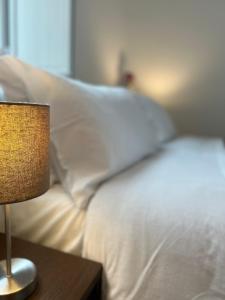 a bed with white pillows and a table with a lamp at Bonadies64 B&B in Salerno