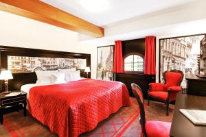 グダニスクにあるホテル グダニスク ブティックの赤いベッドと赤い椅子が備わるホテルルームです。