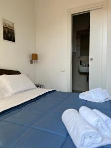 una camera da letto con un letto blu e asciugamani di Bonadies64 B&B a Salerno