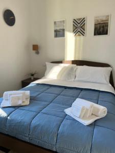a blue bed with towels on top of it at Bonadies64 B&B in Salerno