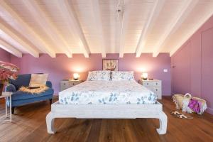 een slaapkamer met een wit bed en een blauwe stoel bij Isola Bella Apartments - Via Villa 28 in Stresa