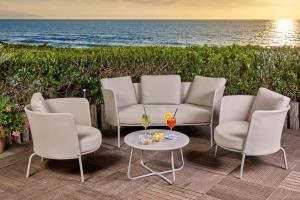 a set of four chairs and a table and a couch at Park Hotel I Lecci in San Vincenzo