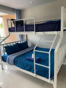 a bedroom with two bunk beds with blue pillows at Atlantis Condo Resort jomtien in Jomtien Beach