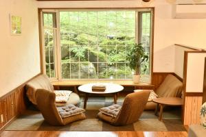 um quarto com cadeiras, uma mesa e uma janela em guest house windy em Yamanakako