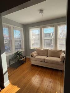 a living room with a couch and some windows at Three Bed One Bath Apt 25 mins to NYC in Belleville