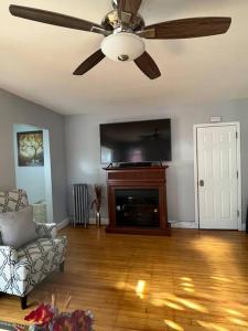 a living room with a ceiling fan and a fireplace at Three Bed One Bath Apt 25 mins to NYC in Belleville