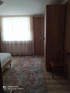 a bedroom with a bed and a window and a rug at Шахдаг in Qusar