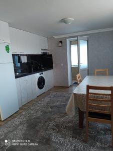 a kitchen with a table and a washing machine at Шахдаг in Qusar