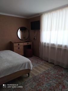 a bedroom with a bed and a mirror and a window at Шахдаг in Qusar