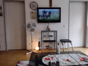 a living room with a table and a tv on the wall at 1 apartment with 2rooms in München in Munich
