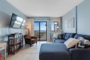 a living room with a blue couch and a chair at Plantation East II in Gulf Shores