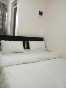 a white bed with two pillows on top of it at The pinnacle in Kikuyu
