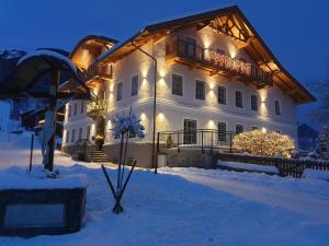 Una gran casa blanca con luces de Navidad en la nieve en Das Weber, en Sankt Jakob in Defereggen