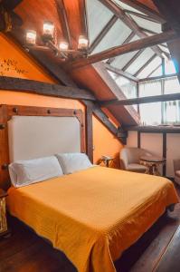 1 dormitorio con cama amarilla en el ático en Casa de los Arcángeles en San Cristóbal de Las Casas