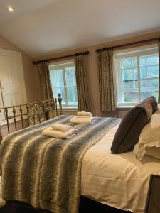 a bedroom with a large bed with two towels on it at Derby Arms Witherslack in Grange Over Sands