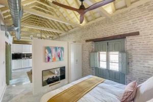 - une chambre avec un lit et une cheminée dans l'établissement Judería de Sevilla V Luxury Apartments, à Séville