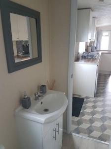 a bathroom with a white sink and a mirror at Lovely 2-Bed Chalet at Robinhood Retreat Free park in Nottingham