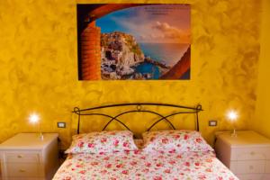 una camera da letto con un letto e un dipinto sul muro di Affittacamere Rosy a La Spezia