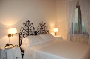 トレンティーノにあるLa Corteのベッドルーム1室(ベッド1台、ランプ付きテーブル2台付)
