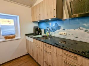kuchnia z blatem, umywalką i oknem w obiekcie Appartement Haus Talblick w Kaprunie