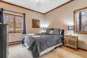 a bedroom with a bed and a tv and windows at Skyleaf 703 in Sugar Mountain