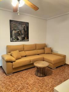 a living room with a brown couch and a table at Aitana Apartment in Gran Alacant