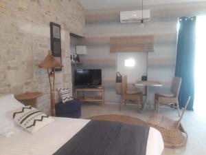 um quarto de hotel com uma cama, uma mesa e cadeiras em Au Domaine du Petit Cercoux em Saint-Saturnin-du-Bois