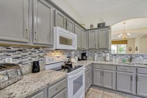 een keuken met witte kasten en witte apparaten bij Mickeys Sunspot - 6 bed Emerald Island Resort pool home in Kissimmee