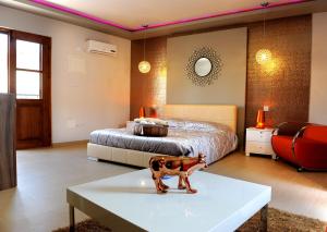 a bedroom with a bed and a table with a horse statue at Esperando in Maroni