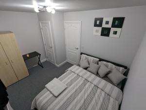 Un dormitorio con una cama con almohadas. en Greatmindz's home away from home en Bloxwich
