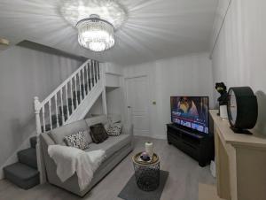 a living room with a couch and a tv at Greatmindz's home away from home in Bloxwich