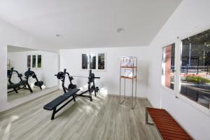 a gym with treadmills and exercise equipment in a room at Park Hotel I Lecci in San Vincenzo