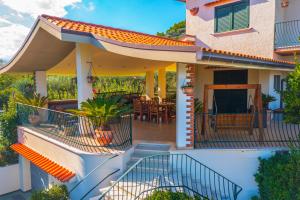 a house with a balcony with a patio at Vista Allegra Pagoda - Villa con piscina in Colonnella