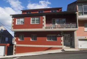 un edificio rojo con un balcón en el lateral. en Bueu: studio Con vistas al mar- 1 room - 2 persons, en Bueu