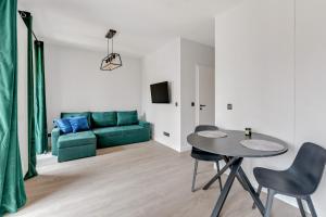 a living room with a green couch and a table at Dom & House - Apartments Old Town Scala in Gdańsk