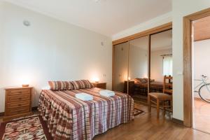 een slaapkamer met een bed en een spiegel bij Best Houses 09 - Peniche Steps from The Beach in Peniche