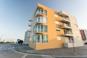 een oranje gebouw met balkons aan de straatkant bij Best Houses 09 - Peniche Steps from The Beach in Peniche