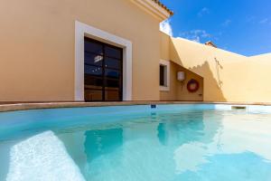a swimming pool in front of a house at Villa Serenity Private Pool Corralejo By Holidays Home in Corralejo