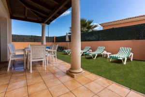 a patio with chairs and a table and chairs at Villa Serenity Private Pool Corralejo By Holidays Home in Corralejo