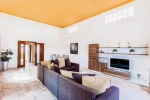 a living room with a couch and a tv at Villa Serenity Private Pool Corralejo By Holidays Home in Corralejo