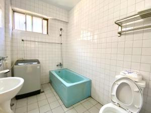 豐原的住宿－天井老屋，浴室设有卫生间和蓝色浴缸。