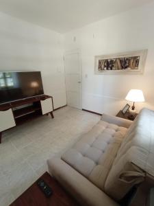 a living room with a couch and a flat screen tv at Castillo del Lago Carlos Paz - Solo Familiar in Villa Carlos Paz