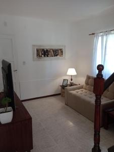 a living room with a couch and a tv at Castillo del Lago Carlos Paz - Solo Familiar in Villa Carlos Paz
