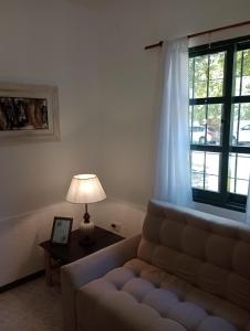 sala de estar con sofá y ventana en Castillo del Lago Carlos Paz - Solo Familiar en Villa Carlos Paz