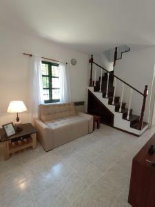 a living room with a couch and a staircase at Castillo del Lago Carlos Paz - Solo Familiar in Villa Carlos Paz